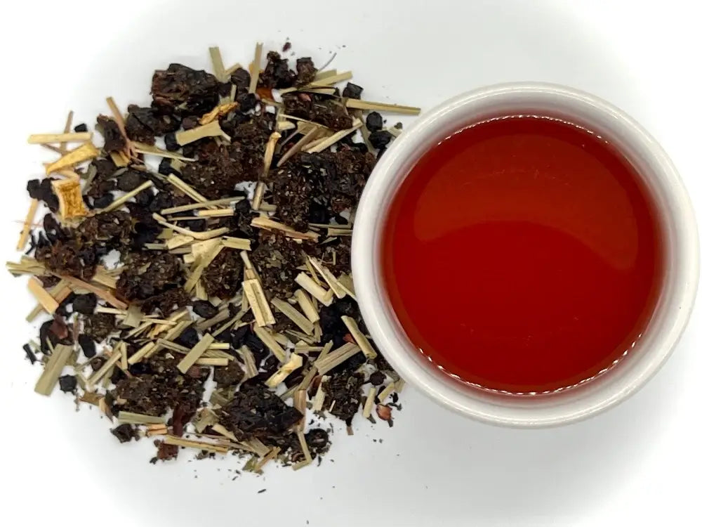 Tea leaves and a cup of brewed tea on a white background